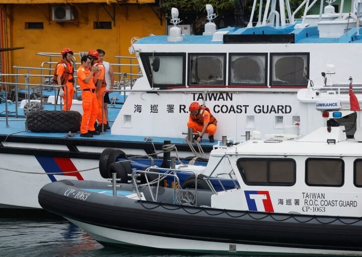 Taiwan Coast Guard members pose for pictures while onboard a boat moored at a fishing harbour near Keelung, Taiwan, on July 24, 2024. (REUTERS/Carlos Garcia Rawlins)