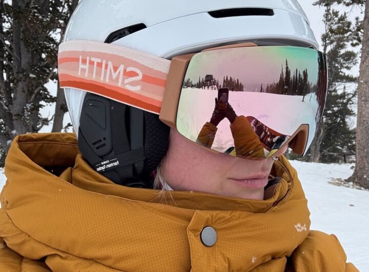 Selfie of a person in yellow puffy winter jacket wearing a white POC Obex Connect helmet and reflective goggles with...